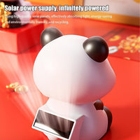 Cute solar-powered panda dashboard accessory from a side angle.