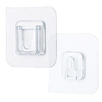 Single clear adhesive hook securely mounted on a smooth wall surface.