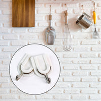 Close-up of a sturdy adhesive wall hook applied to a smooth ceramic tile surface.