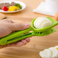 Hand holding the Multipurpose Slicer, creating uniform slices of fresh strawberries.