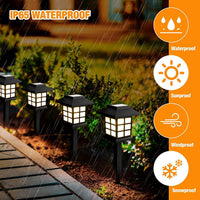 Two solar pathway lights installed along a garden path, casting warm light.