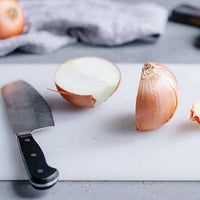 Sturdy plastic chopping board, ideal for daily food preparation in Indian kitchens.