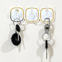Close-up of a clear plastic transparent adhesive hook with a stainless steel hook.