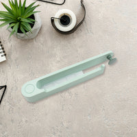 Compact plastic towel holder with a sturdy round hook for easy hanging.