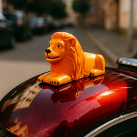 Orange-gold lion dashboard ornament enhancing car interior style