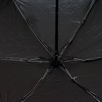 A DrizzlePro portable umbrella closed and ready to be stored, highlighting its compact design.