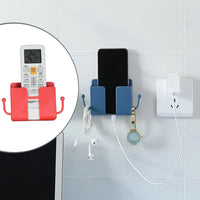 Wall mounted phone charging dock and remote control holder in a modern home.