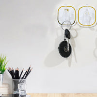 Transparent adhesive wall hook securely holding a heavy object, demonstrating its 3kg load capacity.