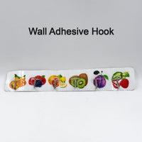 Versatile transparent adhesive hook holding kitchen utensils on a wall.