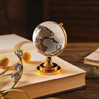 Crystal World Globe with golden stand, placed on a table as a sophisticated office decor item.