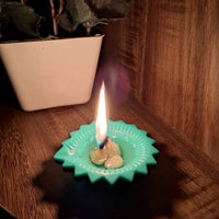 Close-up of two silicone diyas, one lit and one unlit, showcasing their craftsmanship.