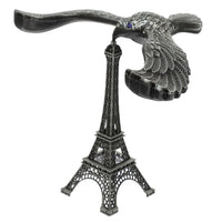 A hand demonstrating the Balancing Eagle Toy's stability by placing it on a fingertip, separate from its stand.