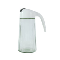 Glass oil bottle dispenser among kitchen condiments and utensils