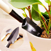 A child happily using the shovel to dig in the garden with their new tools.