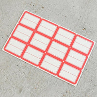 Close-up view of red and white rectangular self-adhesive label stickers